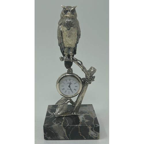 3 - A Continental silver coloured figure of an owl, perched on a branch, inset with a clock below, on a ... 