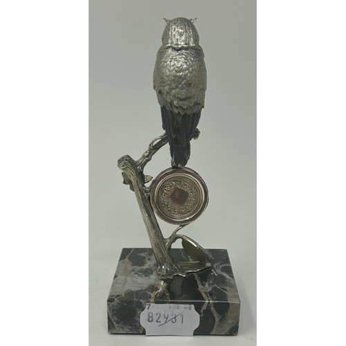 3 - A Continental silver coloured figure of an owl, perched on a branch, inset with a clock below, on a ... 