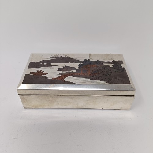 81 - A Japanese silver table cigarette box, decorated a snowcapped mountain, 15.5 cm wide