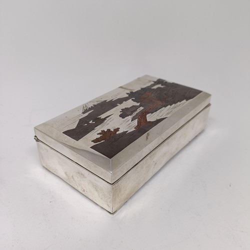 81 - A Japanese silver table cigarette box, decorated a snowcapped mountain, 15.5 cm wide