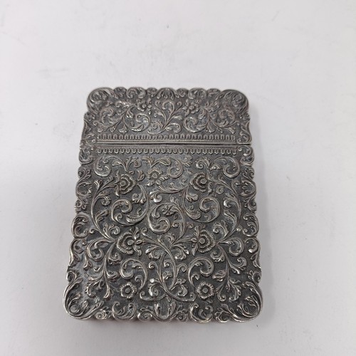 119 - An Indian silver coloured metal visiting card case, initialled, decorated scrolling foliage, 9.5 cm