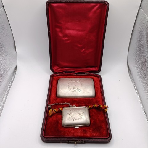 136 - A Continental silver coloured metal cigarette case, and a matching snuff box, named, in a fitted cas... 