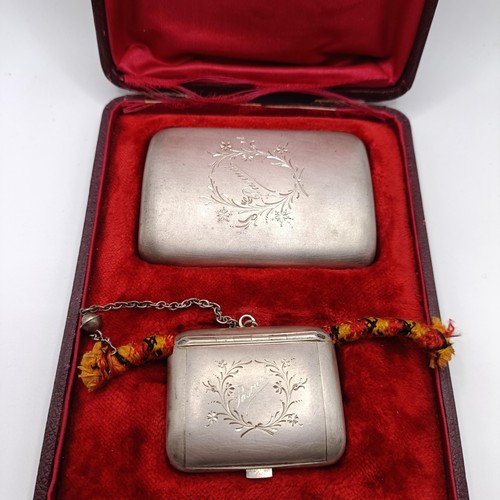 136 - A Continental silver coloured metal cigarette case, and a matching snuff box, named, in a fitted cas... 