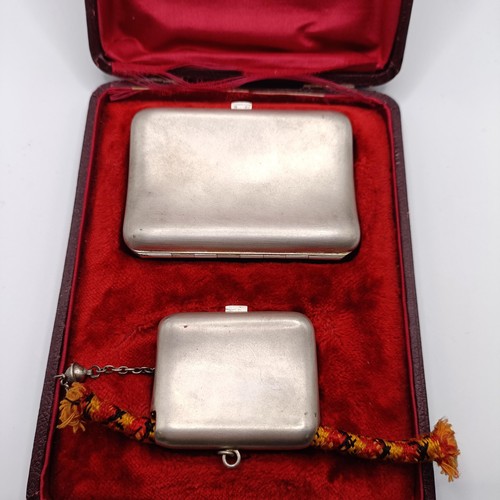 136 - A Continental silver coloured metal cigarette case, and a matching snuff box, named, in a fitted cas... 