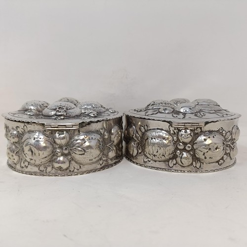 21 - A pair of Continental silver coloured metal boxes and covers, embossed fruit in high relief, 9 cm di... 