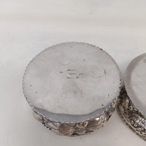 21 - A pair of Continental silver coloured metal boxes and covers, embossed fruit in high relief, 9 cm di... 