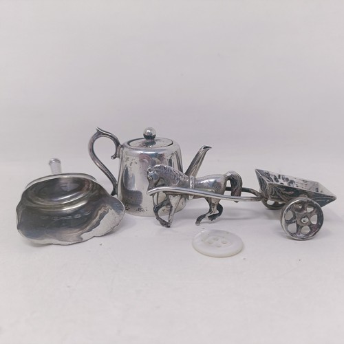 10 - A George V silver miniature teapot, a caddy spoon in the form of a shovel, and a silver coloured met... 