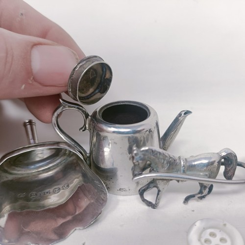 10 - A George V silver miniature teapot, a caddy spoon in the form of a shovel, and a silver coloured met... 