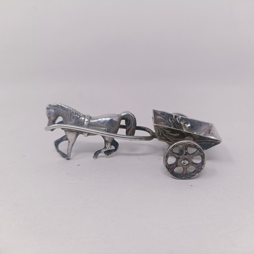 10 - A George V silver miniature teapot, a caddy spoon in the form of a shovel, and a silver coloured met... 