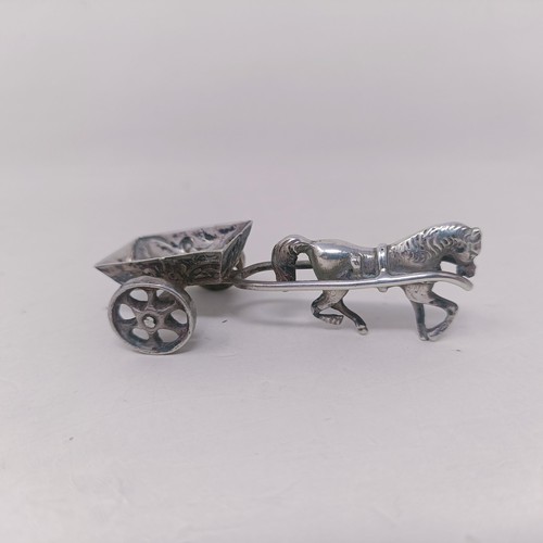 10 - A George V silver miniature teapot, a caddy spoon in the form of a shovel, and a silver coloured met... 