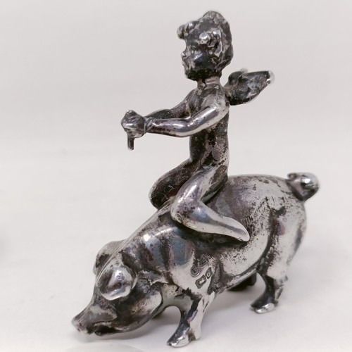 11 - A silver figure, in the form of a cherub riding a pig, some losses, and a silver coloured metal mode... 