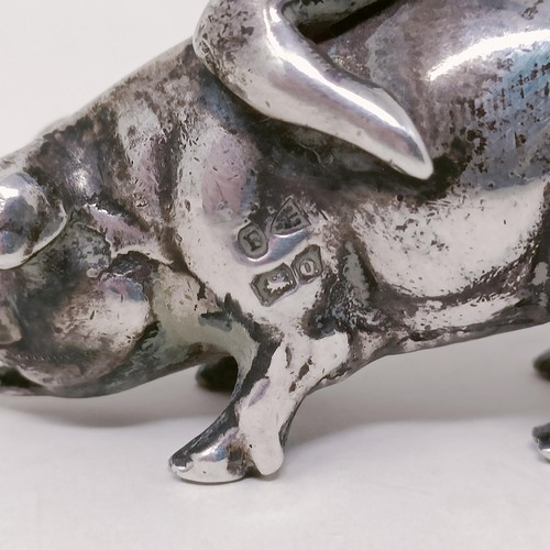 11 - A silver figure, in the form of a cherub riding a pig, some losses, and a silver coloured metal mode... 