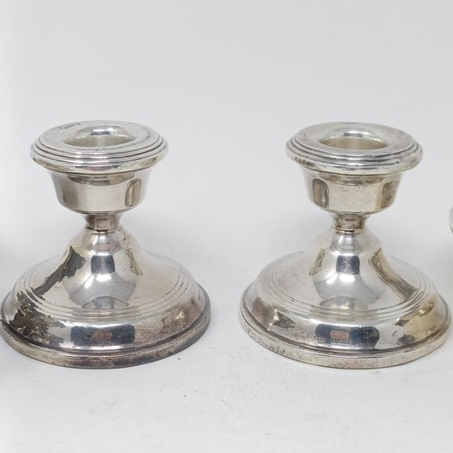 94 - A pair of silver squat candlesticks, a cheese scoop, and three silver dishes, weighable silver 5.5 o... 