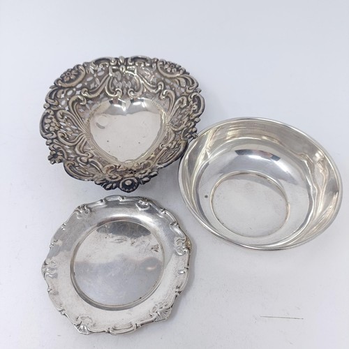 94 - A pair of silver squat candlesticks, a cheese scoop, and three silver dishes, weighable silver 5.5 o... 