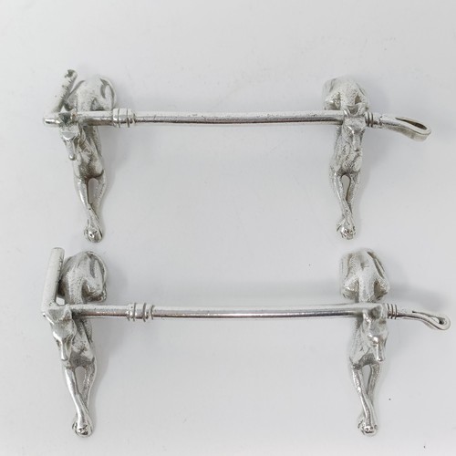 106 - A pair of Continental silver coloured metal novelty knife rests, in the form of dogs, with a crop re... 