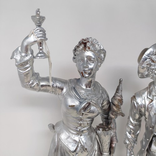 317 - A pair of silvered figures, representing wine, 47 cm, a silvered group of a Native American girl, wi... 