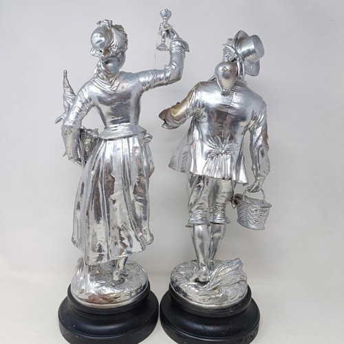 317 - A pair of silvered figures, representing wine, 47 cm, a silvered group of a Native American girl, wi... 