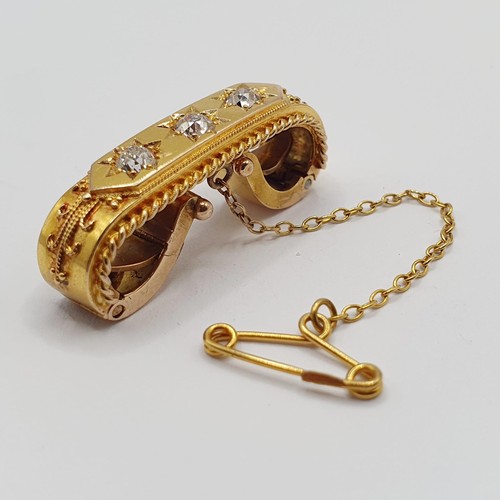 877 - A yellow coloured metal and three stone diamond brooch, with a clip back type setting, and a safety ... 