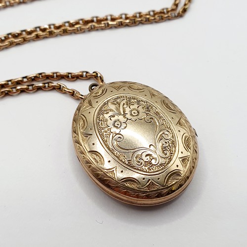 913 - An early 20th century yellow metal and black enamel memorial locket, on a yellow metal chain