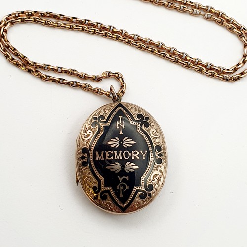 913 - An early 20th century yellow metal and black enamel memorial locket, on a yellow metal chain