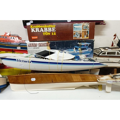 414 - A model boat, 29 cm wide, three model kits, boxed, and four other model boats (8)