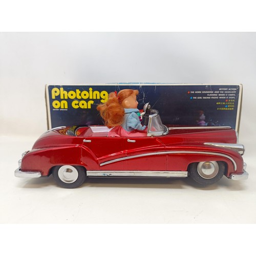 429 - A Japanese tinplate photoing on car, boxed, two Fisher Price toy televisions, and assorted other toy... 