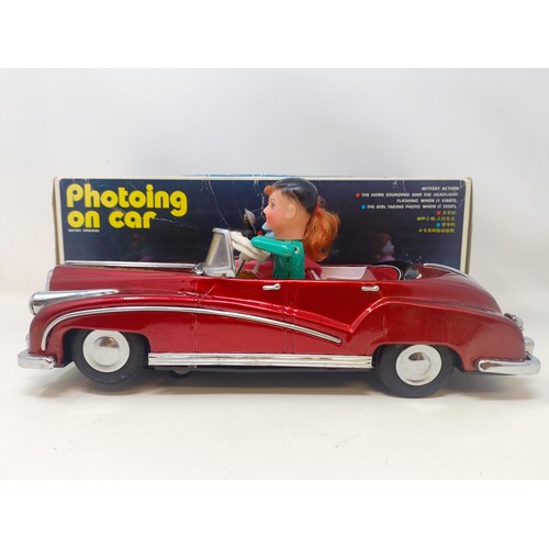 429 - A Japanese tinplate photoing on car, boxed, two Fisher Price toy televisions, and assorted other toy... 