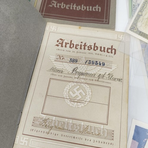 228 - A group of nine German pay books, another booklet, a group of German Third Reich coins, and assorted... 