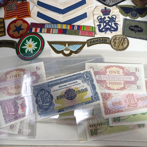 233 - A group of assorted British Army issue banknotes, up to £5, assorted ribbons, insignia and other ite... 