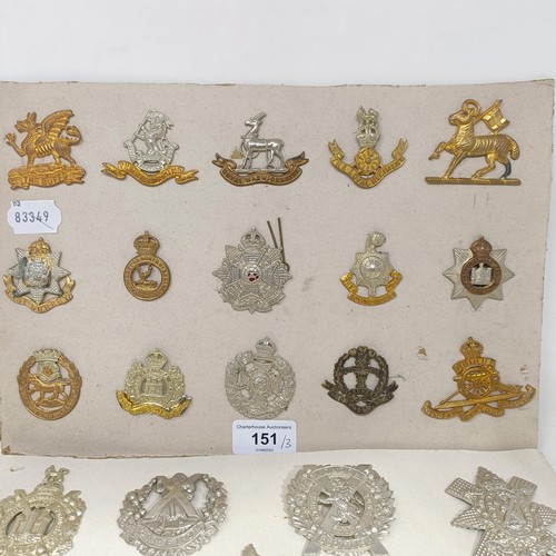 151 - A group of assorted military badges, mounted on three cards