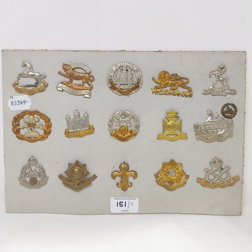 151 - A group of assorted military badges, mounted on three cards