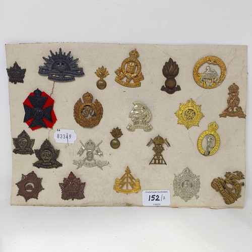 152 - A group of assorted shoulder titles, buttons and military badges, on three cards