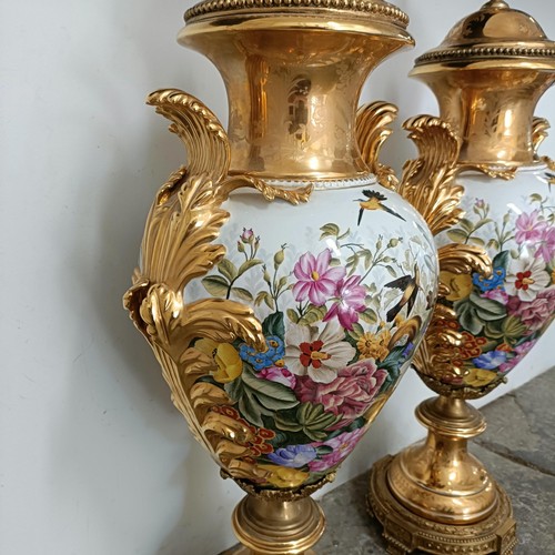 300 - A large pair Continental porcelain vases and covers, decorated birds and flowers, with gilt handles ... 