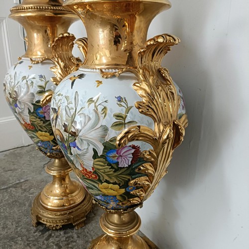 300 - A large pair Continental porcelain vases and covers, decorated birds and flowers, with gilt handles ... 