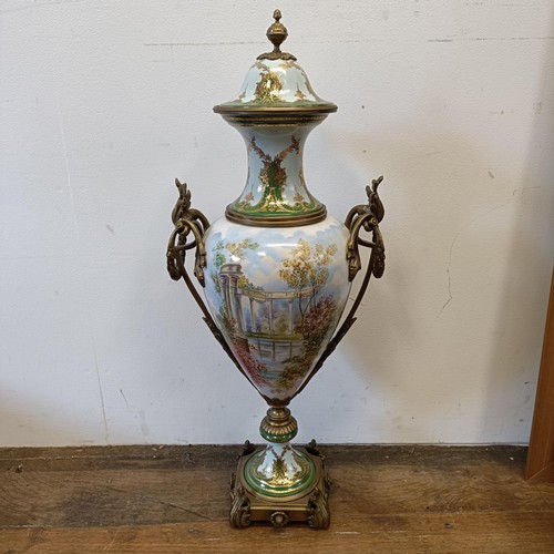 301 - A Continental porcelain vase and cover, decorated a ruin, with gilt metal mounts, 74 cm high