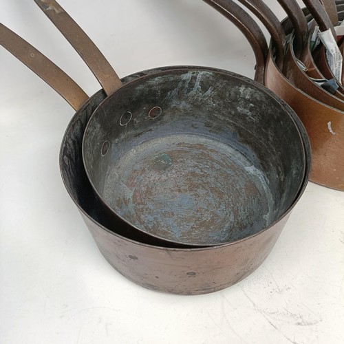 343 - A graduated set of five copper and metal saucepans, and two others (7)