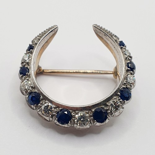 848 - An early 20th century yellow coloured metal, diamond and sapphire crescent shaped brooch, 3 cm wide