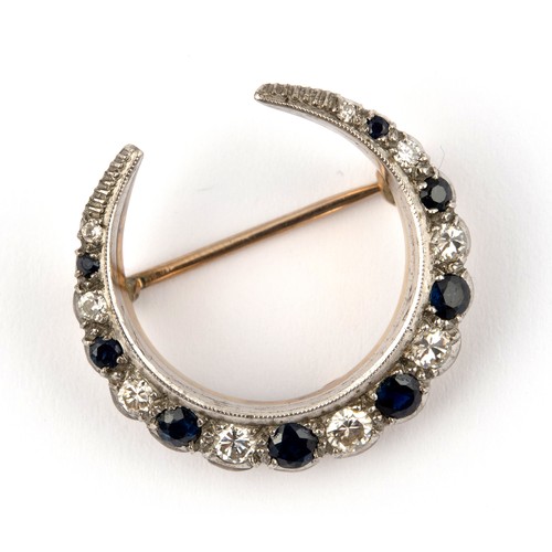 848 - An early 20th century yellow coloured metal, diamond and sapphire crescent shaped brooch, 3 cm wide