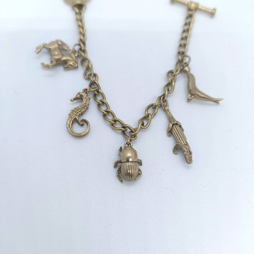 910 - A silver gilt charm bracelet, and assorted charms