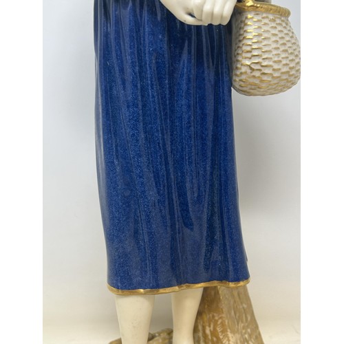 1501 - A Royal Worcester figure of a lady holding a basket, 44 cm high