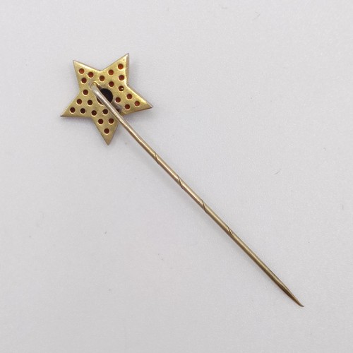 599 - A 20th century yellow coloured metal and garnet stick pin, in the form of a star Provenance:  From a... 