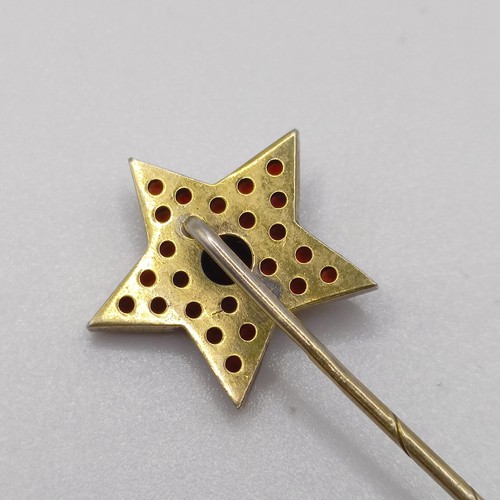 599 - A 20th century yellow coloured metal and garnet stick pin, in the form of a star Provenance:  From a... 