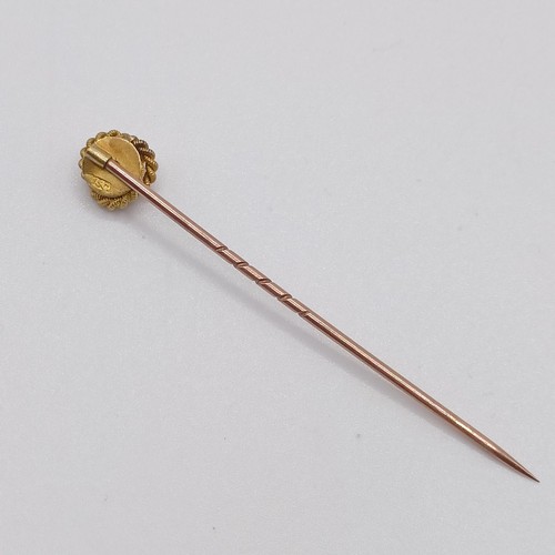 594 - A late 19th/early 20th century yellow coloured metal and diamond stick pin, in the form of a knot Pr... 