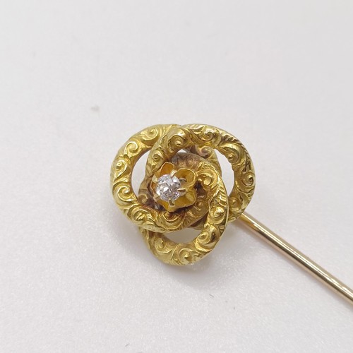 592 - A yellow coloured metal and diamond stick pin, in the form of a knot  Provenance:  From a single own... 