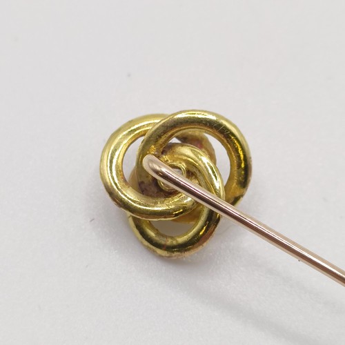 592 - A yellow coloured metal and diamond stick pin, in the form of a knot  Provenance:  From a single own... 