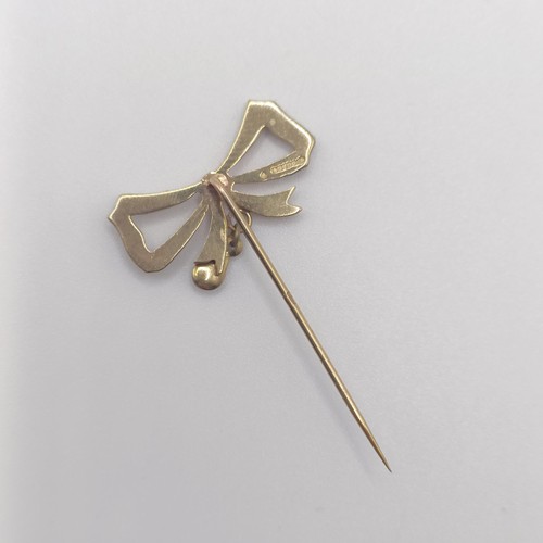 589 - An early 20th century 9ct gold and seed pearl stick pin, in the form of a bow  Provenance:  From a s... 