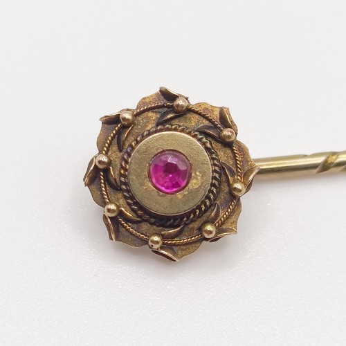 588 - A late 19th/early 20th century yellow metal and red stone stick pin  Provenance:  From a single owne... 