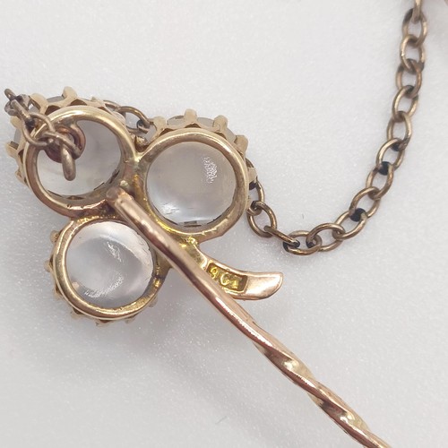 582 - A late 19th/early 20th century yellow metal and moonstone double stick pin, linked with a chain Prov... 