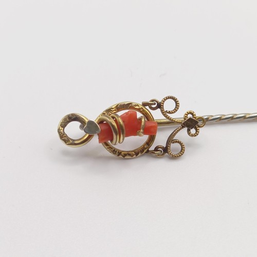 579 - A late 19th/early 20th century yellow metal and coral stick pin  Provenance:  From a single owner co... 