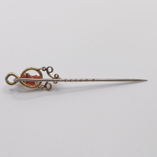 579 - A late 19th/early 20th century yellow metal and coral stick pin  Provenance:  From a single owner co... 